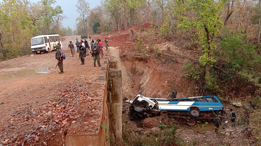 In this photo provided by the Indo Tibetan Border Police, security officers patrol the site of a bombing in Narayanpur district of Chhattisgarh state, India, Tuesday, March 23, 2021. At least four Indian policemen were killed and more than a dozen wounded Tuesday in a roadside bombing carried out by Maoist rebels in their stronghold in the country's east, police said. The area is a known stronghold of Maoist rebels, who say they are inspired by Chinese revolutionary leader Mao Zedong. (Indo Tibetan Border Police via AP)