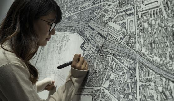 Chinese artist Yang Qian using dots to recreate an aerial view of Wuhan, China, under lockdown at her studio in Wuhan in central China&#39;s Hubei province on Sunday, Jan. 24, 2021. Yang, who worked as a volunteer delivering vital supplies to hospitals and residents during the city&#39;s pandemic 76-day lockdown, is using her art work to make sure that history is not forgotten. (AP Photo/Ng Han Guan)