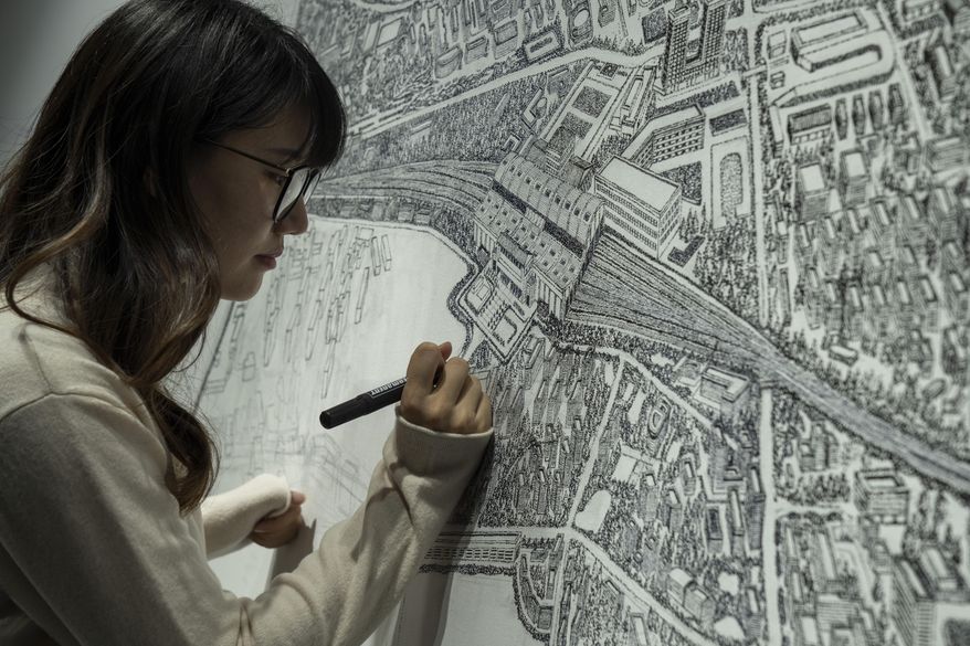 Chinese artist Yang Qian using dots to recreate an aerial view of Wuhan, China, under lockdown at her studio in Wuhan in central China&#x27;s Hubei province on Sunday, Jan. 24, 2021. Yang, who worked as a volunteer delivering vital supplies to hospitals and residents during the city&#x27;s pandemic 76-day lockdown, is using her art work to make sure that history is not forgotten. (AP Photo/Ng Han Guan)