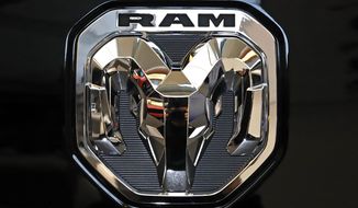 FILE - This Feb. 13, 2020 photo shows the Ram truck logo at the 2020 Pittsburgh International Auto Show in Pittsburgh.  The company that makes heavy-duty diesel Ram trucks is telling some owners to park them outdoors due to the risk of an engine fire. Fiat Chrysler, now part of Stellantis, is recalling just over 20,000 of the trucks mainly in the U.S. and Canada.   (AP Photo/Gene J. Puskar)