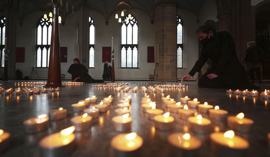 Candles are lit during the National Day of Reflection at Blackburn Cathedral, on the anniversary of the first national lockdown to prevent the spread of coronavirus, in Blackburn, England, Tuesday March 23, 2021. The U.K. has a lot to reflect on a year after British Prime Minister Boris Johnson first announced that the country would go into lockdown to slow the fast-spreading coronavirus. A national day of reflection taking place on Tuesday will remember more than 126,000 people who died after contracting the virus. (Peter Byrne/PA via AP)