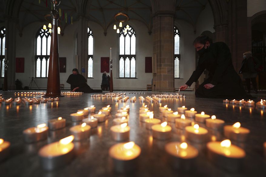 Candles are lit during the National Day of Reflection at Blackburn Cathedral, on the anniversary of the first national lockdown to prevent the spread of coronavirus, in Blackburn, England, Tuesday March 23, 2021. The U.K. has a lot to reflect on a year after British Prime Minister Boris Johnson first announced that the country would go into lockdown to slow the fast-spreading coronavirus. A national day of reflection taking place on Tuesday will remember more than 126,000 people who died after contracting the virus. (Peter Byrne/PA via AP)