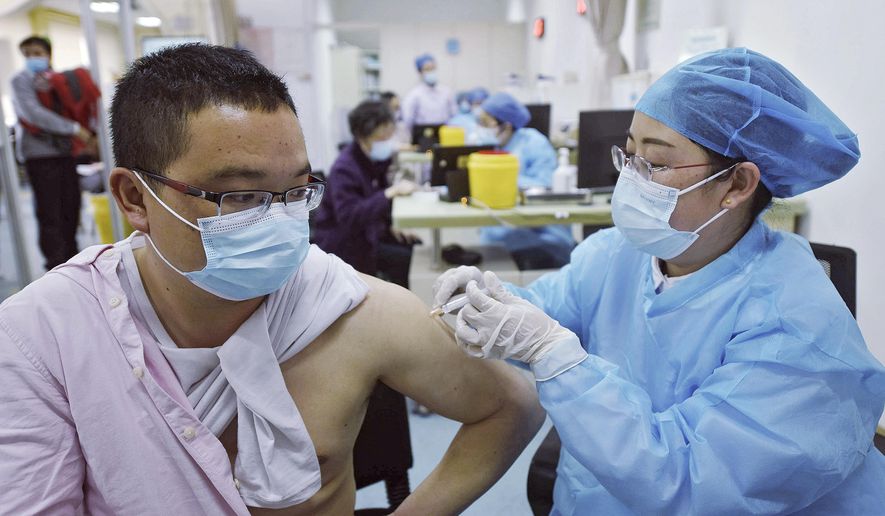 A man wearing a face mask to help curb the spread of the coronavirus receives a shot of Sinovac COVID-19 vaccine at a community health center in Hangzhou in east China&#39;s Zhejiang province on Monday, March 15, 2021. Sinovac said its COVID-19 vaccine is safe in children ages 3-17, based on preliminary data, and it has submitted the data to Chinese drug regulators for approval. More than 70 million shots of Sinovac&#39;s vaccine have been given worldwide, including in China. (Chinatopix Via AP)