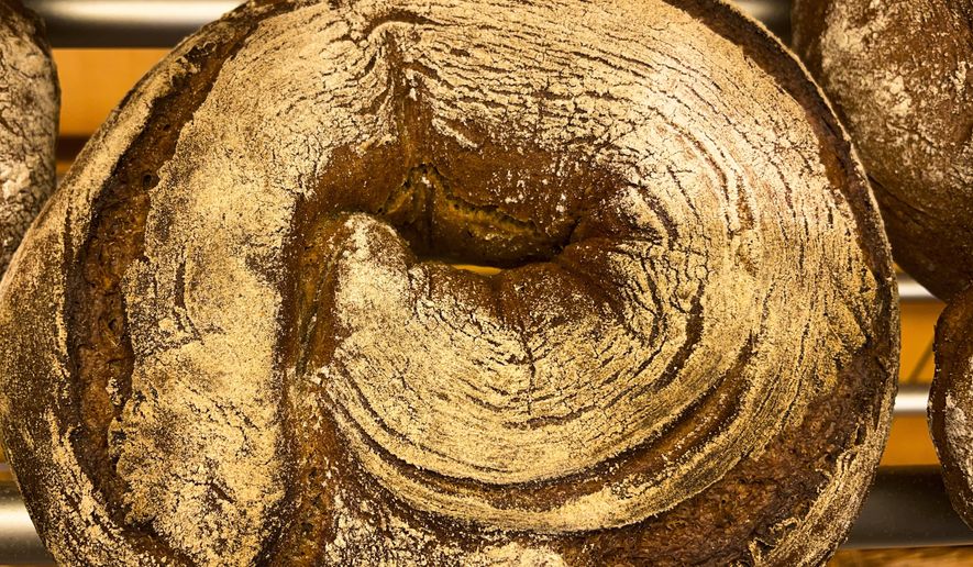 A bread loaf that was baked with beer is displayed in the Coelven bakery in Duesseldorf, Germany, Tuesday, March 23, 2021. About 6,000 litres of the renowned copper-colored 'Altbier' of the historic Fuechschen brewery remain unsold and nearing its expiry date. The brewery now works with craft bakers who use the beer to make bread, with about twelve bakeries producing the grain bread and are giving the additional bonus of a bottle of Fuechschen's Altbier free of charge with every loaf.(AP Photo/Daniel Niemann)