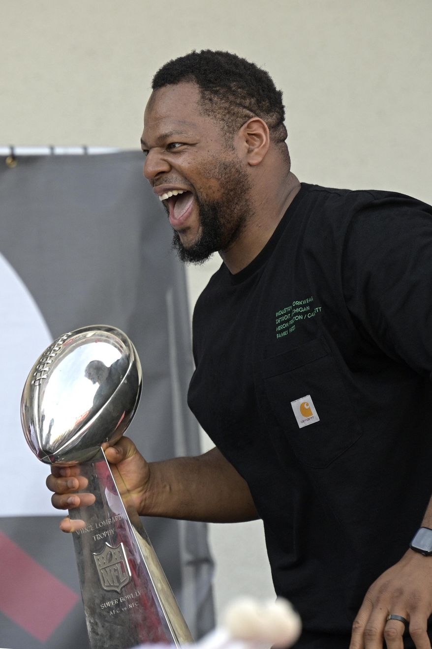 Tampa Bay Buccaneers defensive lineman Ndamukong Suh celebrates with the Vince Lombardi trophy during a celebration of their Super Bowl 55 victory over the Kansas City Chiefs after taking part in a boat parade, Wednesday, Feb. 10, 2021, in Tampa, Fla. (AP Photo/Phelan M. Ebenhack)