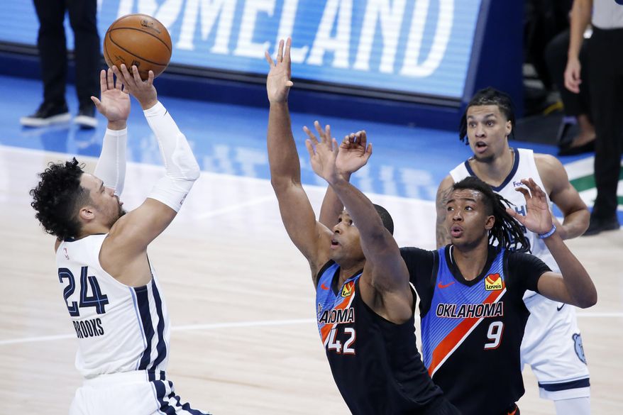 Memphis Grizzlies forward Dillon Brooks (24) takes a shot against Oklahoma City Thunder center Al Horford (42) and center Moses Brown (9) while Memphis Grizzlies forward Brandon Clarke (15) looks on during the first half of an NBA basketball game, Wednesday, March 24, 2021, in Oklahoma City. (AP Photo/Garett Fisbeck)