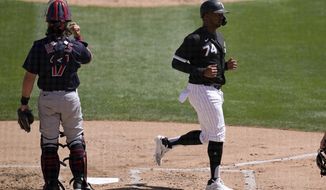 Chicago White Sox&#39;s Eloy Jimenez, right, scores a run as Cleveland Indians catcher Austin Hedges pauses at home plate during the first inning of a spring training baseball game Saturday, March 20, 2021, in Phoenix. (AP Photo/Ross D. Franklin)