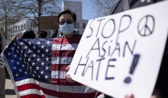 Lucy Lee, of Marietta, Ga., holds an American flag while rallying outside of the Georgia State Capitol in Atlanta during a unity &#39;Stop Asian Hate&#39; rally Saturday afternoon, March 20, 2021. (AP Photo/Ben Gray)