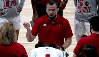 Louisville head coach Jeff Walz talks to his players during the first half of a college basketball game against Northwestern in the second round of the women&#39;s NCAA tournament at the Alamodome in San Antonio, Wednesday, March 24, 2021. (AP Photo/Charlie Riedel)