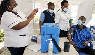 A nurse, left, prepares a shot of AstraZeneca COVID-19 vaccine, manufactured by the Serum Institute of India and provided through the global COVAX initiative, from a portable cold storage box, center, in Machakos, Kenya, Wednesday, March 24, 2021. AstraZeneca&#39;s repeated missteps in reporting vaccine data coupled with a blood clot scare could do lasting damage to the credibility of a shot that is the linchpin in the global strategy to stop the coronavirus pandemic, potentially even undermining vaccine confidence more broadly, experts say. (AP Photo/Brian Inganga)