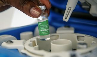 A vial of the AstraZeneca COVID-19 vaccine, manufactured by the Serum Institute of India and provided through the global COVAX initiative, is removed from a portable cold storage box in preparation for a vaccination, in Machakos, Kenya, Wednesday, March 24, 2021. AstraZeneca&#39;s repeated missteps in reporting vaccine data coupled with a blood clot scare could do lasting damage to the credibility of a shot that is the linchpin in the global strategy to stop the coronavirus pandemic, potentially even undermining vaccine confidence more broadly, experts say. (AP Photo/Brian Inganga)