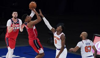 Washington Wizards&#39; Rui Hachimura (8) shoots over New York Knicks&#39; RJ Barrett (9) as Wizards&#39; Alex Len (27) and Knicks&#39; Taj Gibson (67) watch during the second half of an NBA basketball game Thursday, March 25, 2021, in New York. (AP Photo/Frank Franklin II, Pool)