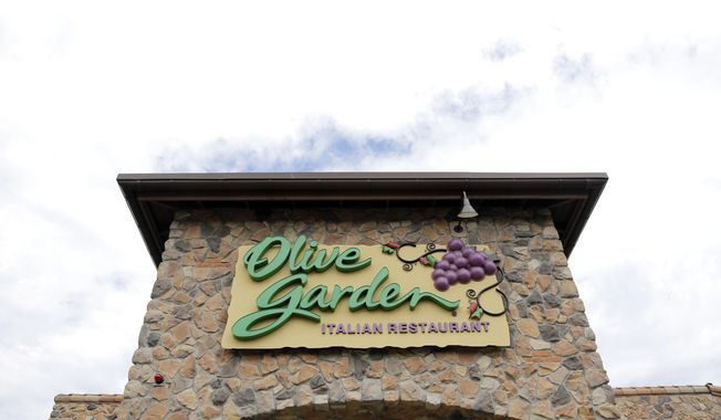 FILE - This  June 27, 2016 file photo shows an Olive Garden restaurant in Methuen, Mass.  Darden Restaurants says every hourly employee will earn at least $10 per hour including tips starting March 29, 2021. That will rise to $12 per hour in 2023. Orlando, Florida-based Darden, which also owns LongHorn Steakhouse, Cheddar’s Scratch Kitchen and others, is also giving one-time bonuses of up to $300 to nearly 90,000 hourly employees.  (AP Photo/Elise Amendola, File)