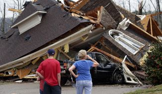 Residents survey damage to homes after a tornado touched down south of Birmingham, Ala. in the Eagle Point community damaging multiple homes, Thursday, March 25, 2021. Authorities reported major tornado damage Thursday south of Birmingham as strong storms moved through the state. The governor issued an emergency declaration as meteorologists warned that more twisters were likely on their way.  (AP Photo/Butch Dill)