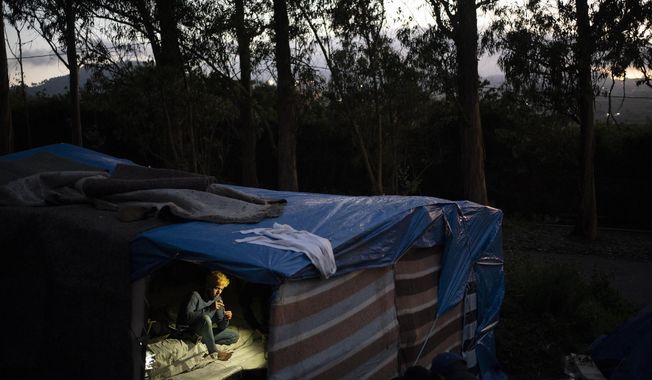 A migrant rests in Las Raices camp in San Cristobal de la Laguna, in the Canary Island of Tenerife, Spain, Wednesday, March 17, 2021. Several thousand migrants have arrived on the Spanish archipelago in the first months of 2021. Due to the terrible living conditions and the poor quality of food and water at the Las Raices camp, some migrants have decided to leave the camp and sleep in shacks in a nearby forest instead. (AP Photo/Joan Mateu)