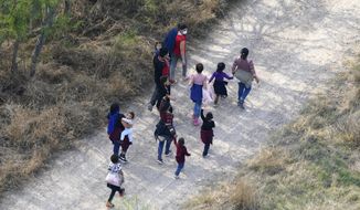 Migrants walk on a dirt road after crossing the U.S.-Mexico border, Tuesday, March 23, 2021, in Mission, Texas. The Biden administration says that it&#39;s working to address the increase in migrants coming to the border. (AP Photo/Julio Cortez) ** FILE **