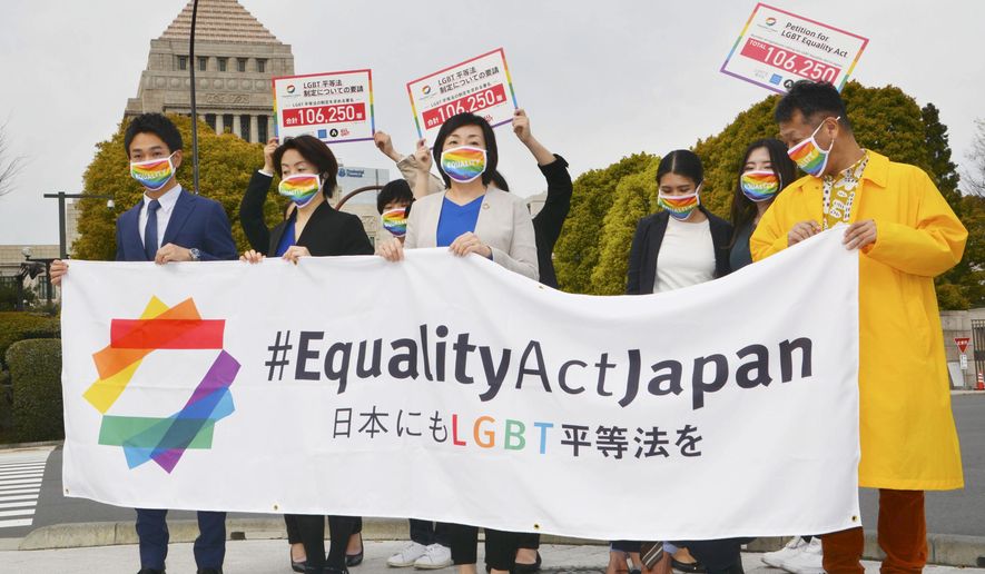 Activists gather in front of parliament before they submit a petition in Tokyo Thursday, March 25, 2021. LGBTQ and other human rights activists submitted a petition with over 106,000 signatures to Japan&#39;s ruling party Thursday, calling for an LGBT equality law to be enacted before the Tokyo Games, saying Japan as host nation should live up to the Olympic charter banning gender and sexual discrimination. (Kyodo News via AP)
