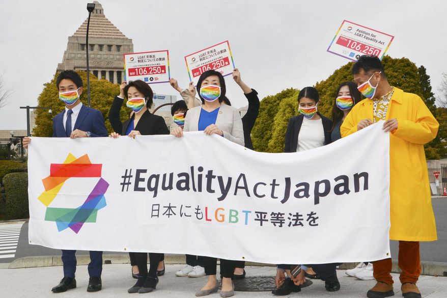 Activists gather in front of parliament before they submit a petition in Tokyo Thursday, March 25, 2021. LGBTQ and other human rights activists submitted a petition with over 106,000 signatures to Japan&#39;s ruling party Thursday, calling for an LGBT equality law to be enacted before the Tokyo Games, saying Japan as host nation should live up to the Olympic charter banning gender and sexual discrimination. (Kyodo News via AP)