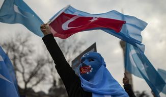 A protester from the Uyghur community living in Turkey waves a Turkish flag during a protest against the visit of China&#39;s Foreign Minister Wang Yi to Turkey, in Istanbul, Thursday, March 25, 2021. Hundreds of Uyghurs staged protests in Istanbul and the capital Ankara, denouncing Wang Yi&#39;s visit to Turkey and demanding that the Turkish government take a stronger stance against human rights abuses in China&#39;s far-western Xinjiang region. (AP Photo/Emrah Gurel)