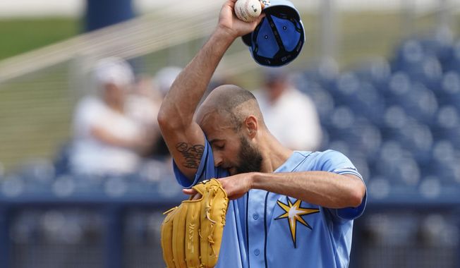 Tampa Bay Rays relief pitcher Nick Anderson wipes his face as he works in the sixth inning of a spring training baseball game against the Minnesota Twins on Wednesday, March 24, 2021, in Port Charlotte, Fla. (AP Photo/John Bazemore)