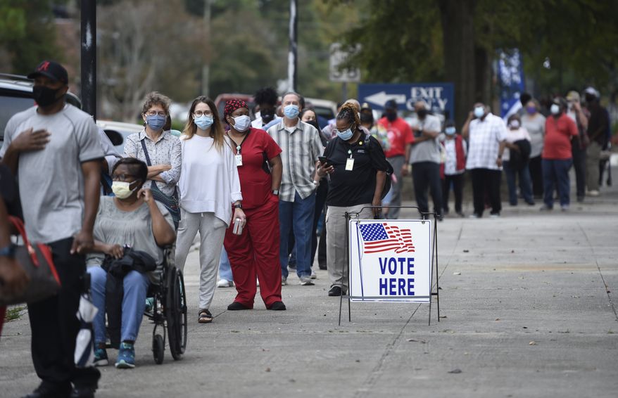 In this Oct. 12, 2020, file photo, people wait in line for early voting at the Bell Auditorium in Augusta, Ga. (Michael Holahan/The Augusta Chronicle via AP, File)