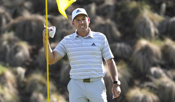 Sergio Garcia, of Spain, celebrates as he take his ball out of the cup after making a hole in one on the fourth hole to win his playoff against Lee Westwood, of England, during a third round match at the Dell Technologies Match Play Championship golf tournament Friday, March 26, 2021, in Austin, Texas. (AP Photo/David J. Phillip)