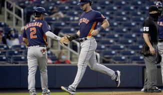 Houston Astros&#x27; Alex Bregman (2) and Kyle Tucker, right, score on a double hit by Houston Astros Carlos Correa during the fourth inning of a spring training baseball game against the Washington Nationals, Wednesday, March 24, 2021, in West Palm Beach, Fla. (AP Photo/Lynne Sladky)