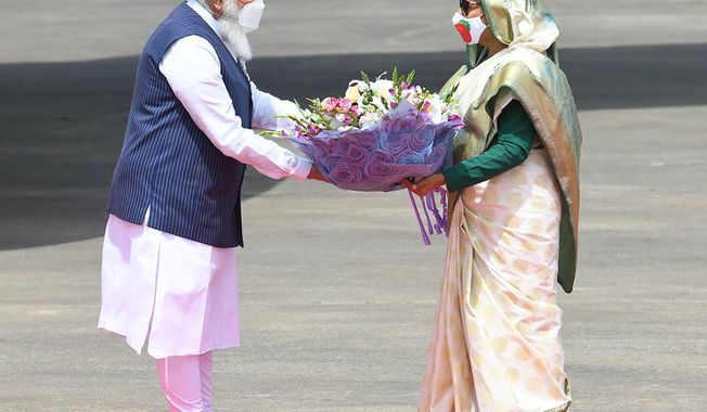In this photo provided by Prime Minister of India Narendra Modi&#x27;s twitter handle, Indian Prime Minister Narendra Modi receives a bouquet of flowers from Bangladesh&#x27;s Prime Minister Sheikh Hasina in Dhaka, Bangladesh, Friday, March 26, 2021. Modi arrived in Bangladesh’s capital on Friday to join celebrations marking 50 years of the country&#x27;s independence, but his trip was not welcomed by all. The two-day visit, his first foreign trip since the coronavirus pandemic began last year, will also include joining commemorations for 100 years since the birth of independence leader Sheikh Mujibur Rahman, the father of current Prime Minister Sheikh Hasina. (Prime Minister of India Narendra Modi&#x27;s twitter handle via AP Photo)