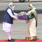 In this photo provided by Prime Minister of India Narendra Modi&#39;s twitter handle, Indian Prime Minister Narendra Modi receives a bouquet of flowers from Bangladesh&#39;s Prime Minister Sheikh Hasina in Dhaka, Bangladesh, Friday, March 26, 2021. Modi arrived in Bangladesh’s capital on Friday to join celebrations marking 50 years of the country&#39;s independence, but his trip was not welcomed by all. The two-day visit, his first foreign trip since the coronavirus pandemic began last year, will also include joining commemorations for 100 years since the birth of independence leader Sheikh Mujibur Rahman, the father of current Prime Minister Sheikh Hasina. (Prime Minister of India Narendra Modi&#39;s twitter handle via AP Photo)