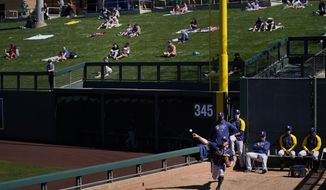 Milwaukee Brewers pitcher Jordan Zimmermann, bottom right, warms up in the bullpen as socially distanced fans watch the Brewers&#39; spring baseball game with the Arizona Diamondbacks in Scottsdale, Ariz., Monday, March 1, 2021. (AP Photo/Jae C. Hong)