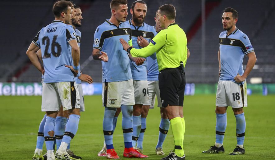 Lazio players argue with the referee during the Champions League, round of 16, second leg soccer match between FC Bayern Munich and Lazio at the soccer Arena stadium in Munich, Germany, Wednesday, March 17, 2021. (AP Photo/Matthias Schrader)