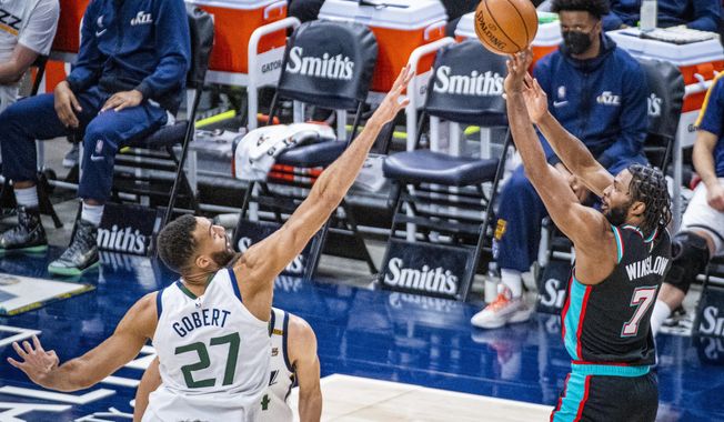 Memphis Grizzlies forward Justise Winslow (7) shoots over Utah Jazz center Rudy Gobert (27) during the first half of an NBA basketball game Friday, March 26, 2021, in Salt Lake City. (AP Photo/Isaac Hale)