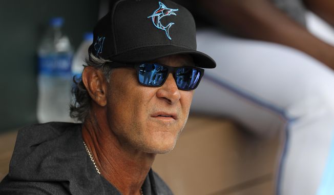 FILE - Miami Marlins manager Don Mattingly looks on from the dugout prior to a spring training baseball game against the Washington Nationals in Jupiter, Fla., in this Tuesday, March 10, 2020, file photo. Mattingly&#x27;s job remains to develop young talent so an underfinanced team can overachieve. He considers his ability to relate to players one of his strengths, perhaps because he was an overachiever himself. (AP Photo/Julio Cortez, File)