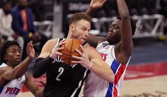 Brooklyn Nets forward Blake Griffin (2) is defended by Detroit Pistons forward Sekou Doumbouya during the first half of an NBA basketball game, Friday, March 26, 2021, in Detroit. (AP Photo/Carlos Osorio)