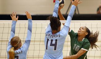FILE - Reagan&#39;s Kyla Waiters, right, spikes the ball past Johnson defenders during a Texas District 26-6A high school volleyball match in San Antonio, Texas, in this Friday, Sept. 22, 2017, file photo. Oregon State leaders are suing to block disclosure of details about an investigation of abuse allegations in their volleyball program, even as they tout a refreshed mission for transparency in wake of their president’s resignation over the handling of sexual-misconduct cases at another school. “I’m guessing there’s something in those records that they don’t want out,” said Dorina Waiters, whose daughter, Kyla, left Oregon State after a year on the volleyball team triggered depression that led to suicidal thoughts.  (Ron Cortes/The San Antonio Express-News via AP, File)