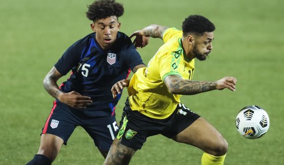 USA&#39;s Chris Richards, left, duels for the ball with Jamaica&#39;s Andre Gray during the international friendly soccer match between USA and Jamaica at SC Wiener Neustadt stadium in Wiener Neustadt, Austria, Thursday, March 25, 2021. (AP Photo/Ronald Zak)