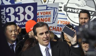 FILE - This Nov. 14, 2018 file photo shows New York State Sen. Michael Gianaris, center, as he calls on supporters to remove the Amazon app from their phones and boycott the company, as he address a coalition rally and press conference, in New York.   Big tech’s outsized influence over society has become one of the biggest battlefronts in state legislatures this year. Lawmakers are taking on tech and social media companies over a wide range of issues, including anti-trust, digital privacy, taxing ad sales, net neutrality and censorship.  (AP Photo/Bebeto Matthews, File)