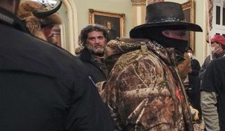 In this Jan. 6, 2021, photo, rioters, including Dominic Pezzola, center with beard, are confronted by U.S. Capitol Police officers outside the Senate Chamber inside the Capitol in Washington. The Proud Boys and Oath Keepers make up a fraction of the more than 300 Trump supporters charged so far in the siege that led to Trump&#39;s second impeachment and resulted in the deaths of five people, including a police officer. But several of their leaders, members and associates have become the central targets of the Justice Department&#39;s sprawling investigation. (AP Photo/Manuel Balce Ceneta, File)