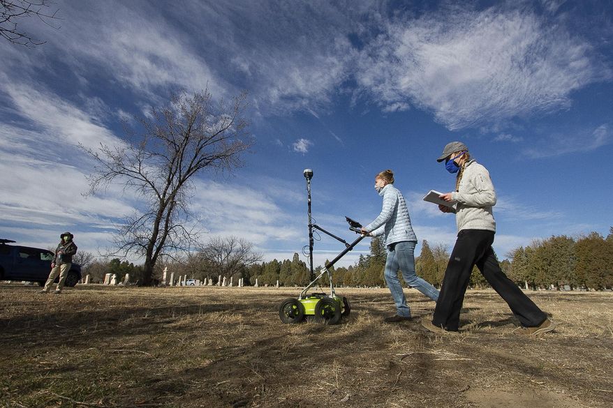 Students from the Colorado School of Mines search the oldest portion of Roselawn Cemetery for mass graves in this photograph taken Friday, March 19, 2021, in Pueblo, Colo. The effort is being staged to document the final resting places for many people who died in the Arkansas River valley flood of 1921, the Spanish flu pandemic in 1918 and a train wreck that took place in 1904 in the area. (Heather Willard/The Pueblo Chieftain via AP)