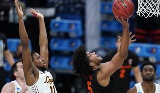 Oregon State guard Ethan Thompson (5) drives to the basket ahead of Loyola Chicago guard Marquise Kennedy (12) during the second half of a Sweet 16 game in the NCAA men&#39;s college basketball tournament at Bankers Life Fieldhouse, Saturday, March 27, 2021, in Indianapolis. (AP Photo/Jeff Roberson)