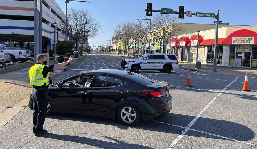 Virginia Beach police redirect traffic on Saturday, March 27, 2021 after late night shootings as they investigate a late night shooting in Virginia Beach, Va. A pair of overnight fatal shootings along the beachfront in Virginia Beach wounded several people in a scene described by authorities on Saturday as “very chaotic.” (Stephen Katz/The Virginian-Pilot via AP)