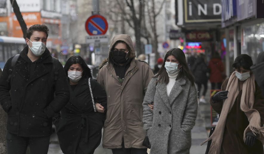 People wearing masks to help protect against the spread of the coronavirus walk in Ankara, Turkey, Friday, March 26, 2021. Daily COVID-19 infections in Turkey surged above 26,000 on Friday, weeks after the government eased restrictions in dozens of provinces under a so-called &amp;quot;controlled normalization&amp;quot; program. (AP Photo/Burhan Ozbilici)