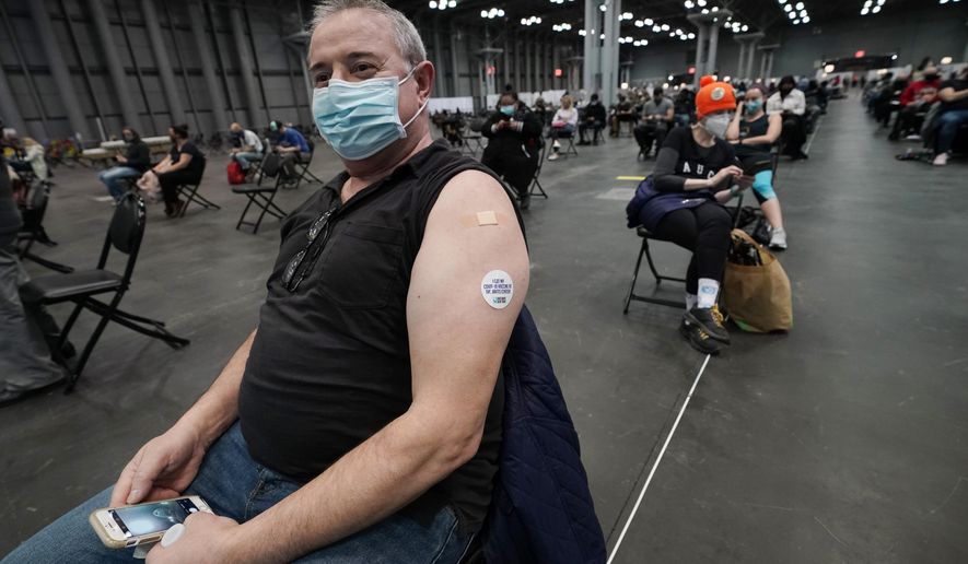 In this file photo a man wears a sticker on his arm that reads, &#39;I got my COVID-19 vaccine at the Javits Center&#39; as he waits during the observation period after getting his vaccine Thursday, March 18, 2021, in New York. (AP Photo/Kathy Willens)  **FILE**