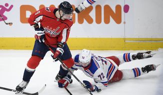 Washington Capitals defenseman Dmitry Orlov (9) battles for the puck against New York Rangers center Filip Chytil (72) during the second period of an NHL hockey game, Sunday, March 28, 2021, in Washington. (AP Photo/Nick Wass)