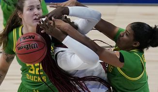 Louisville forward Olivia Cochran, left, is blocked by Oregon forward Nyara Sabally, right, during the first half of a college basketball game in the Sweet Sixteen round of the women&#39;s NCAA tournament at the Alamodome in San Antonio, Sunday, March 28, 2021. (AP Photo/Eric Gay)