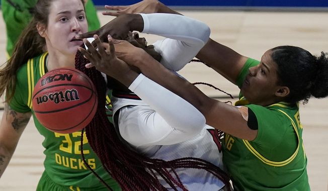 Louisville forward Olivia Cochran, left, is blocked by Oregon forward Nyara Sabally, right, during the first half of a college basketball game in the Sweet Sixteen round of the women&#x27;s NCAA tournament at the Alamodome in San Antonio, Sunday, March 28, 2021. (AP Photo/Eric Gay)