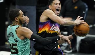 Phoenix Suns guard Devin Booker, right, is fouled by Charlotte Hornets forward P.J. Washington during the second half of an NBA basketball game on Sunday, March 28, 2021, in Charlotte, N.C. (AP Photo/Chris Carlson)