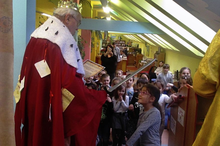Bookseller Jaromir Vytopil, left, appoints the youngest schoolchildren to the order of readers at a library in Pelhrimov, Czech Republic, Thursday, Feb. 7, 2020. Some 25,000 have been killed by COVID-19 in the hard-hit Czech Republic. Jaromir Vytopil was one of them. His everyday presence in the small Czech town of Pelhrimov was something everybody took for granted for seven decades as he had served the generations of readers. The longest serving Czech bookseller, passed away on Nov 9. 2020, at age of 83. (AP Photo/Miroslav Krsek)