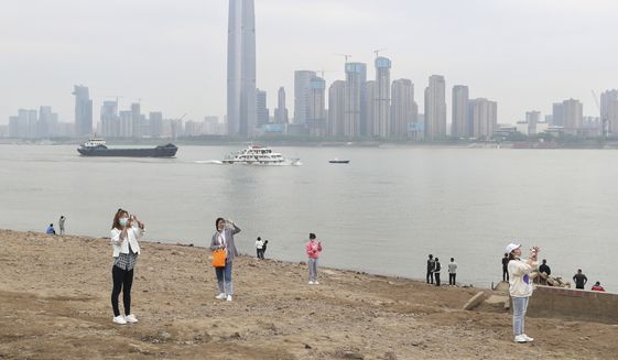 Residents visit the Yangtze River in Wuhan in central China&#39;s Hubei province Monday, March 29, 2021. (Chinatopix Via AP) ** FILE **