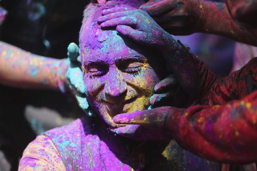 Indians smear colored powder on each other as they celebrate Holi in Jammu, India, Sunday, March 28, 2021. Holi, the Hindu festival of colors, also heralds the arrival of spring. (AP Photo/Channi Anand)